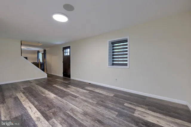 a living room with furniture a flat screen tv and a large window