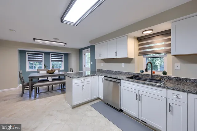 a kitchen with granite countertop a sink a stove and cabinets