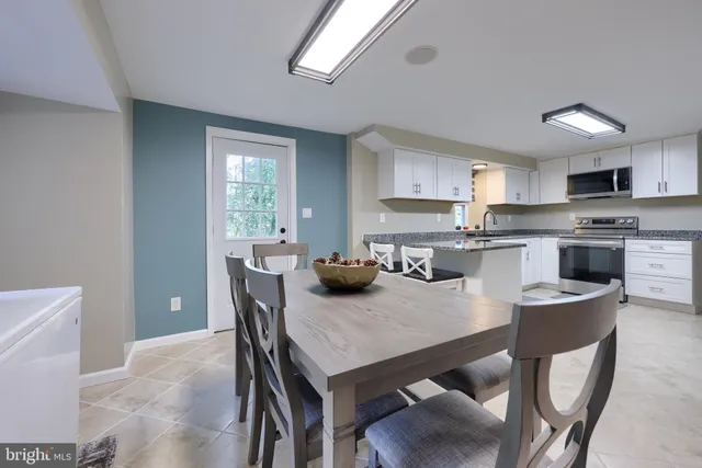 a kitchen with granite countertop a sink cabinets and stainless steel appliances
