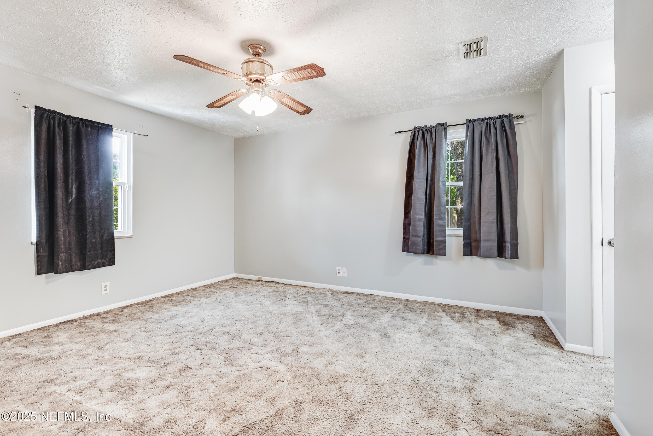 6149 Post Oak Road West Jacksonville, FL 32277 - Photo 16 of 25 an empty room with fan and windows