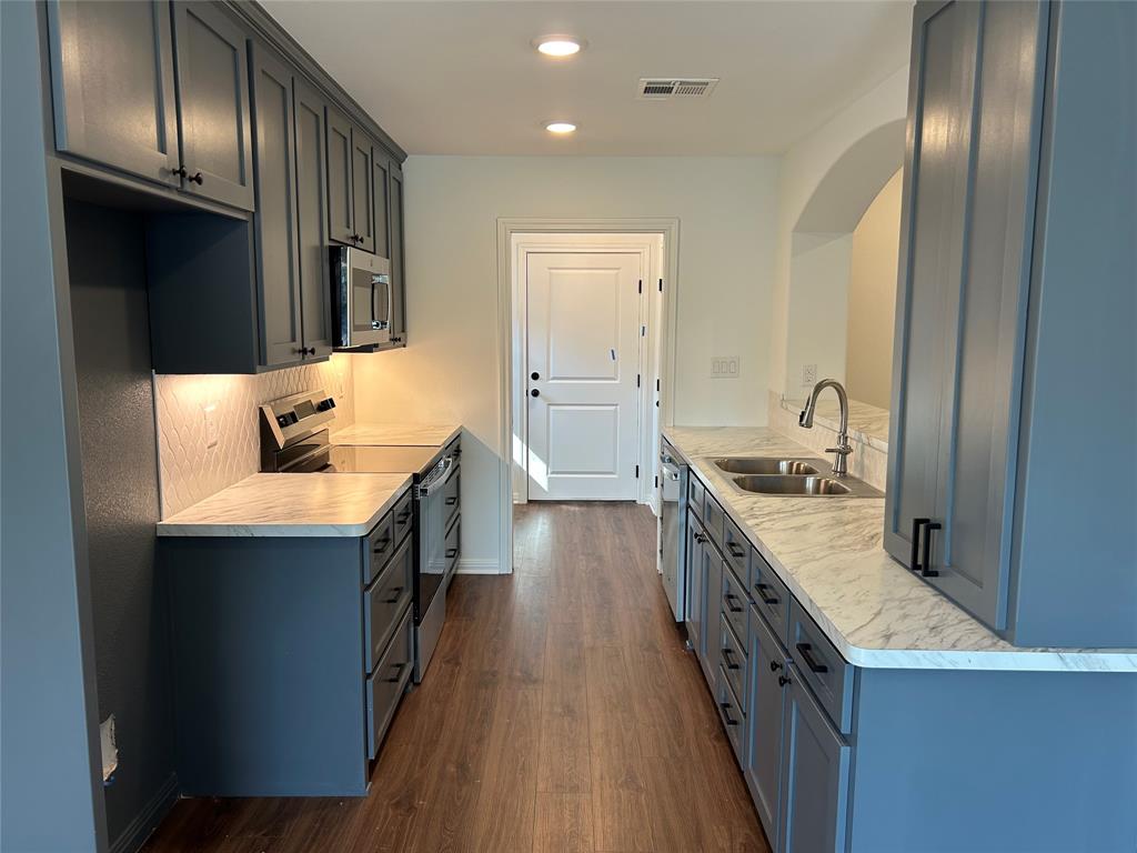 412 Conway Street Waco, TX 76705 - Photo 4 of 8 Kitchen with stainless steel appliances, light countertops, dark wood-style flooring, and recessed lighting