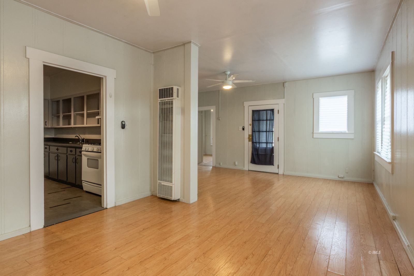 211 South Washington Street Lone Pine, CA 93545 - Photo 11 of 25 an empty room with kitchen view and wooden floor