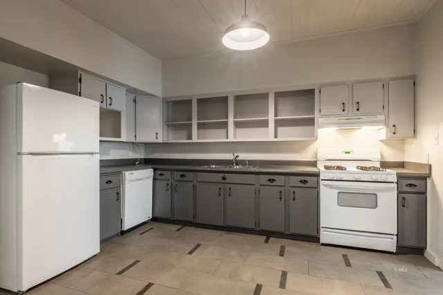 a kitchen with granite countertop a sink stainless steel appliances and cabinets