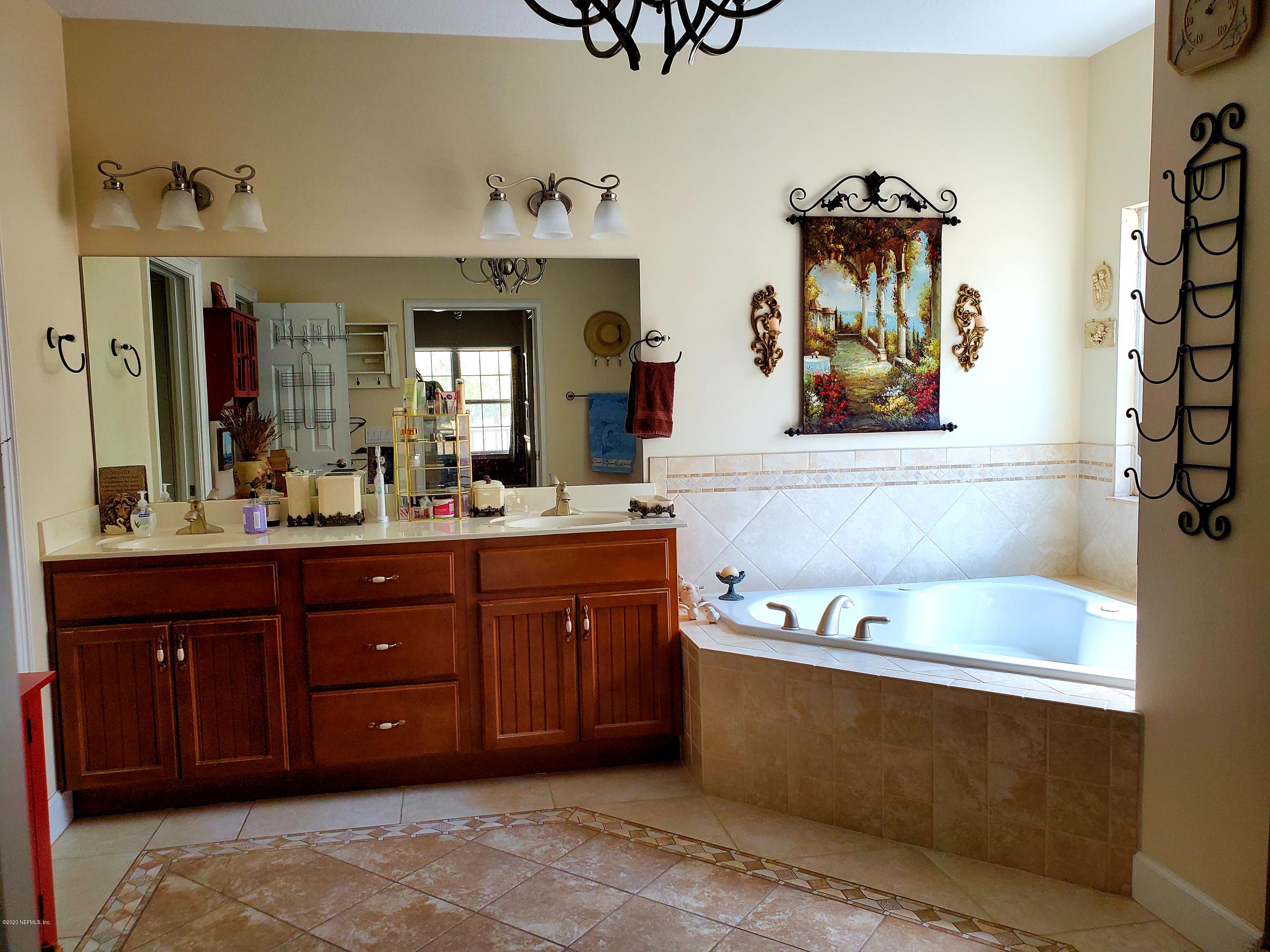 7001 Elfo Road Keystone Heights, FL 32656 - Photo 5 of 6 a spacious bathroom with a tub sink and mirror