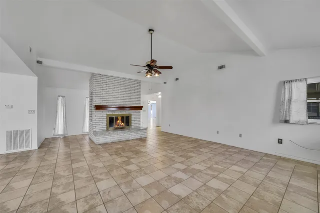 a view of empty room with cabinet and fireplace