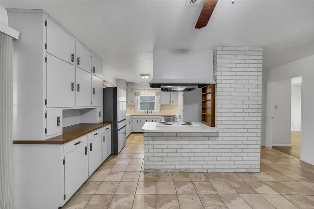 a kitchen with kitchen island a sink appliances and cabinets