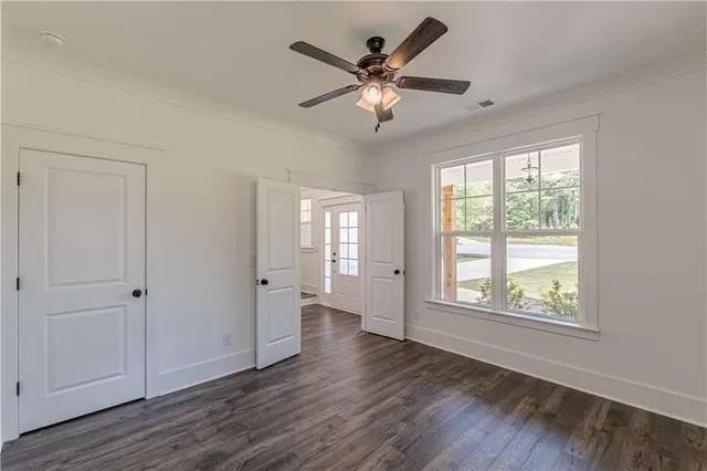 an empty room with windows a fireplace and wooden floor