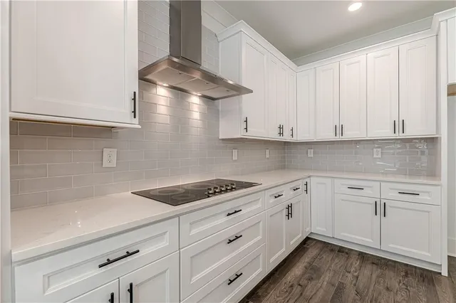 an empty room with wooden floor chandelier fan and windows