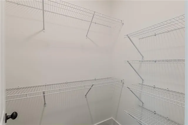 an empty room with windows and ceiling fan view