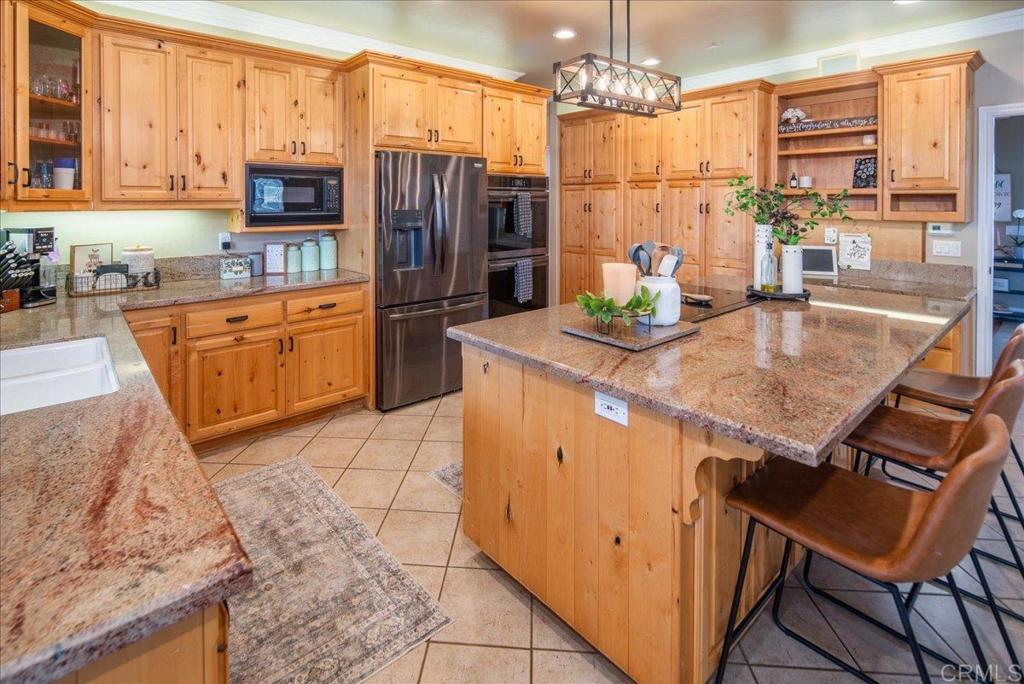 25057 Poderio Drive Ramona, CA 92065 - Photo 9 of 36 a kitchen with stainless steel appliances granite countertop a refrigerator a stove and a sink with granite countertops