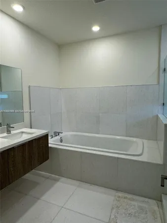 a bathroom with a bathtub a sink and a mirror