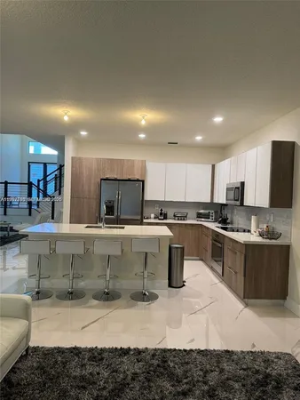 a large kitchen with kitchen island a sink a stove a counter space and cabinets