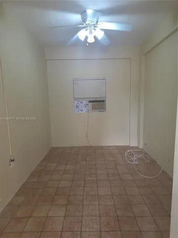 a view of an empty room and chandelier fan