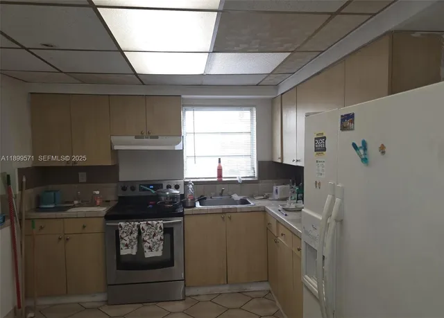 a kitchen with stainless steel appliances a stove a sink and a refrigerator