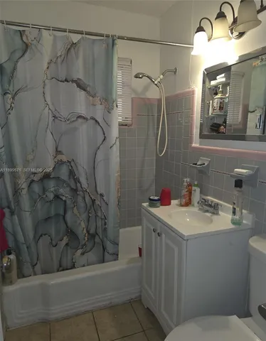a bathroom with a sink vanity granite toilet and shower