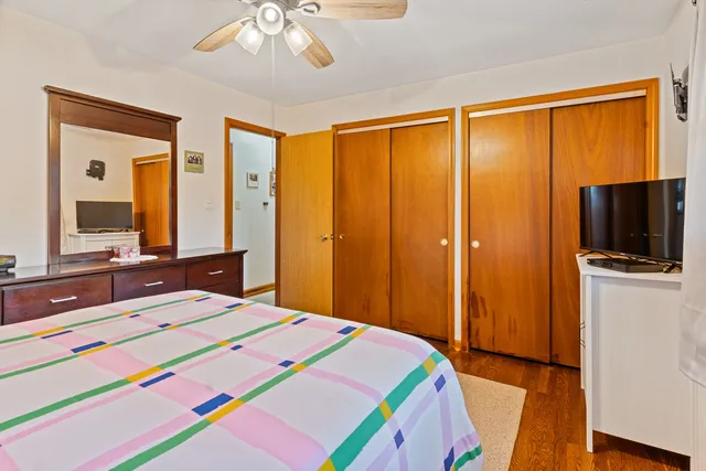 a bedroom with a bed a mirror and a flat tv