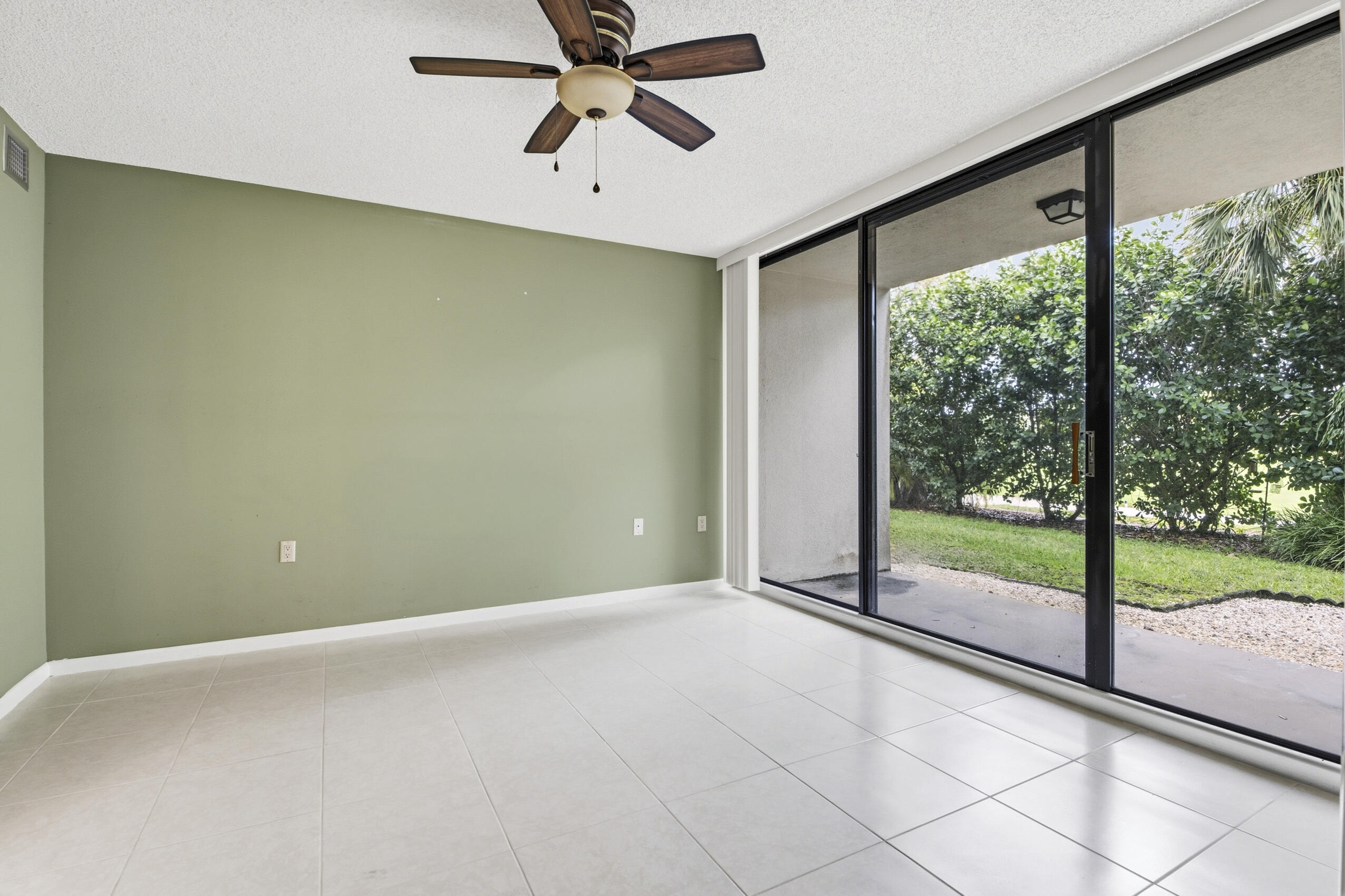 6145 Balboa Circle, Unit 103 Boca Raton, FL 33433 - Photo 13 of 31 an empty room with wooden floor and windows