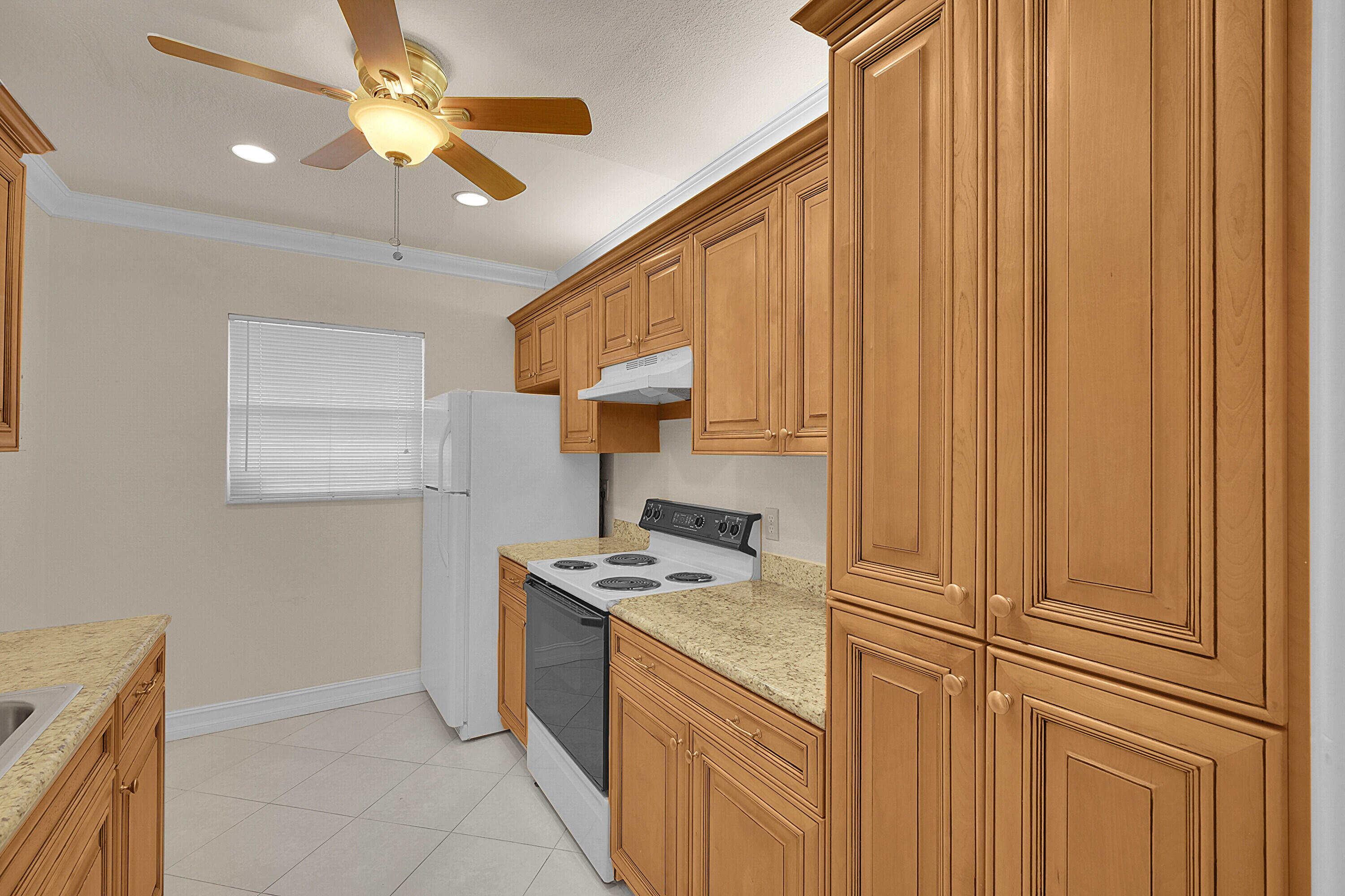 2340 Southwest 22nd Avenue, Unit 306 Delray Beach, FL 33445 - Photo 12 of 33 a kitchen with stainless steel appliances granite countertop a stove a sink and a refrigerator