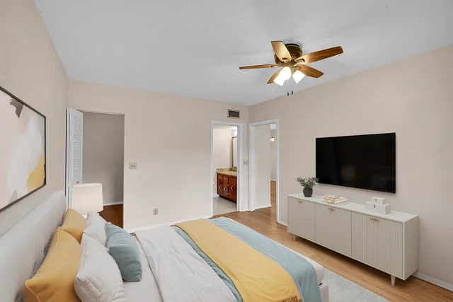 an empty room with wooden floor and a ceiling fan