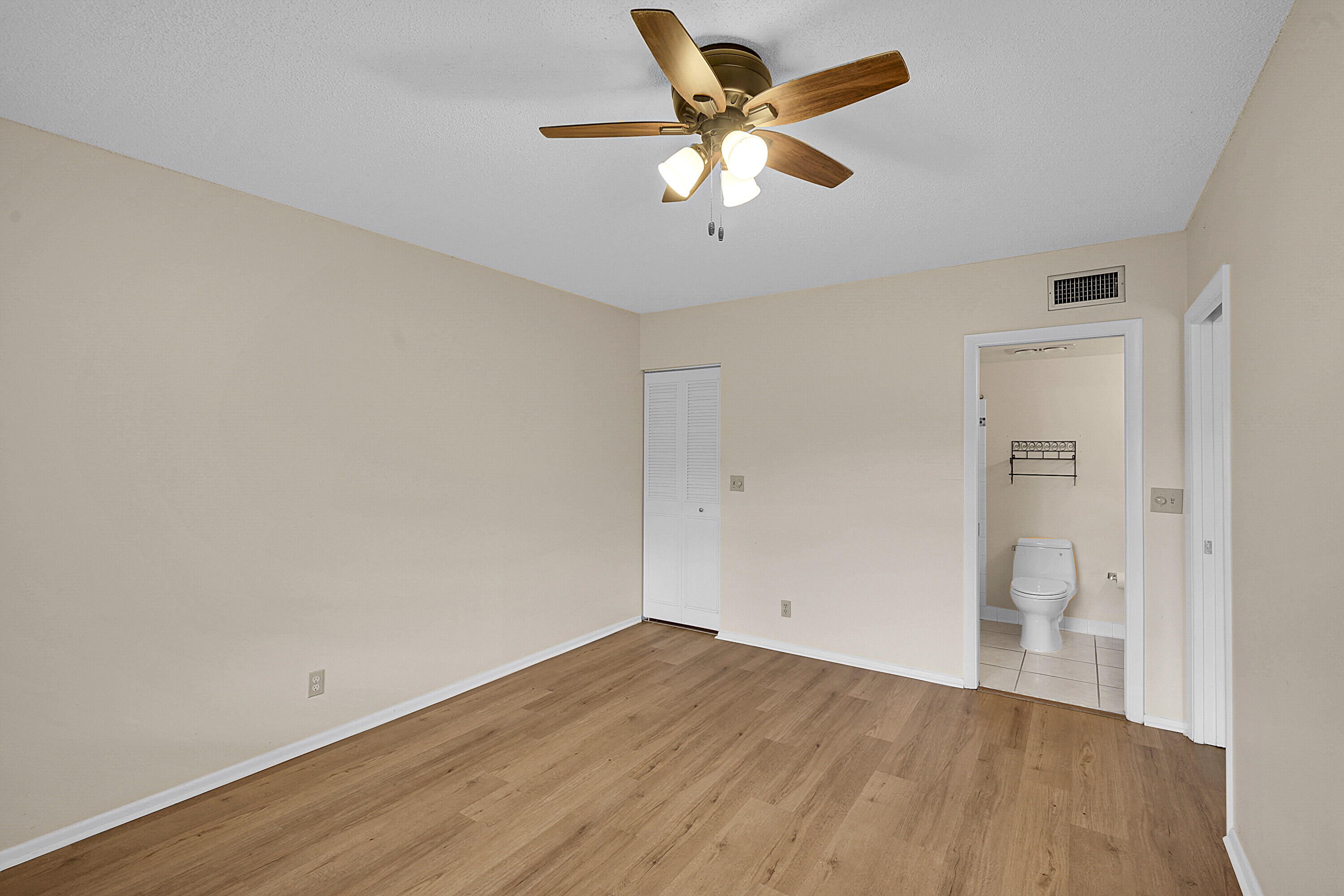 2340 Southwest 22nd Avenue, Unit 306 Delray Beach, FL 33445 - Photo 17 of 33 an empty room with wooden floor and a ceiling fan