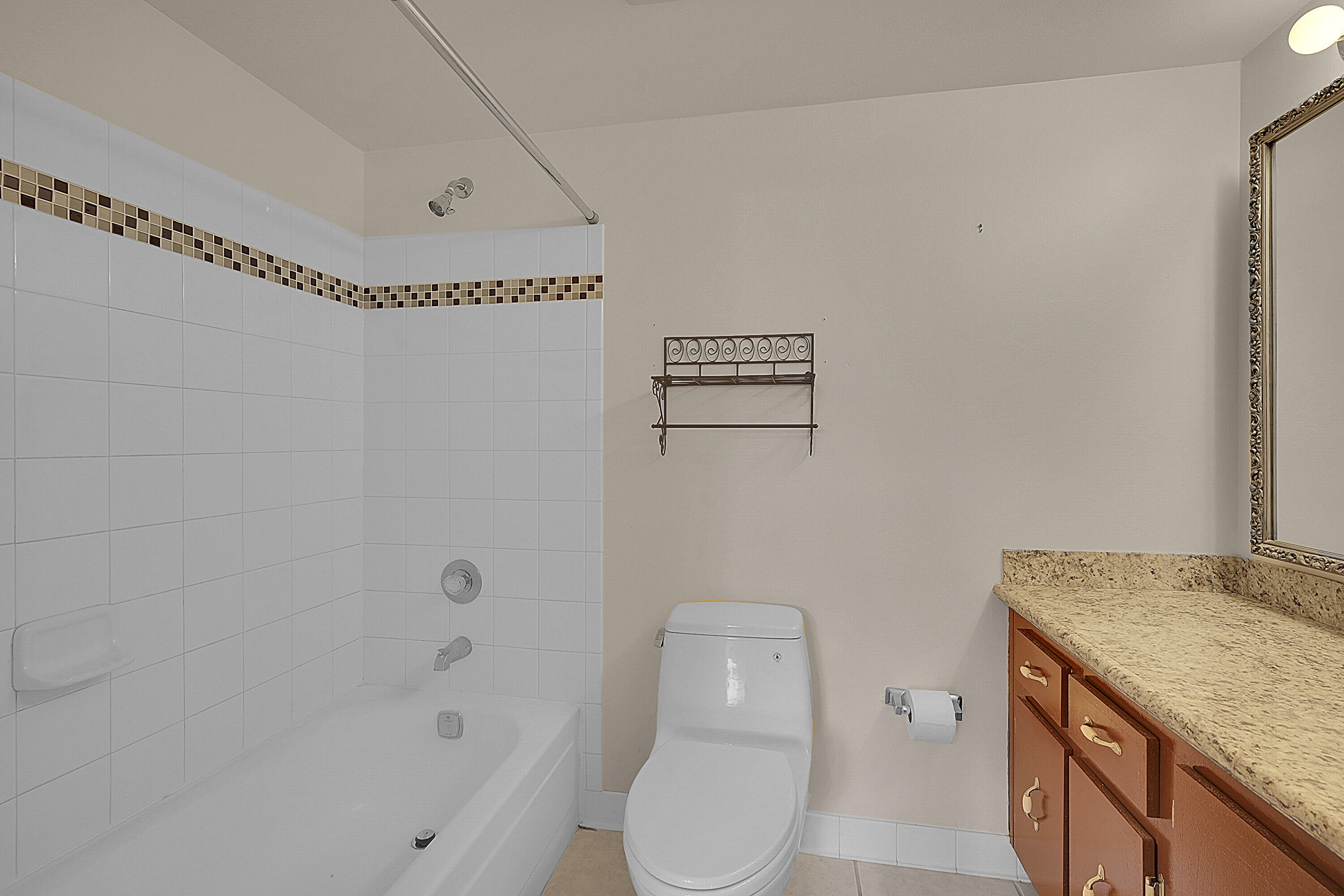 2340 Southwest 22nd Avenue, Unit 306 Delray Beach, FL 33445 - Photo 22 of 33 a bathroom with a granite countertop sink a toilet and shower