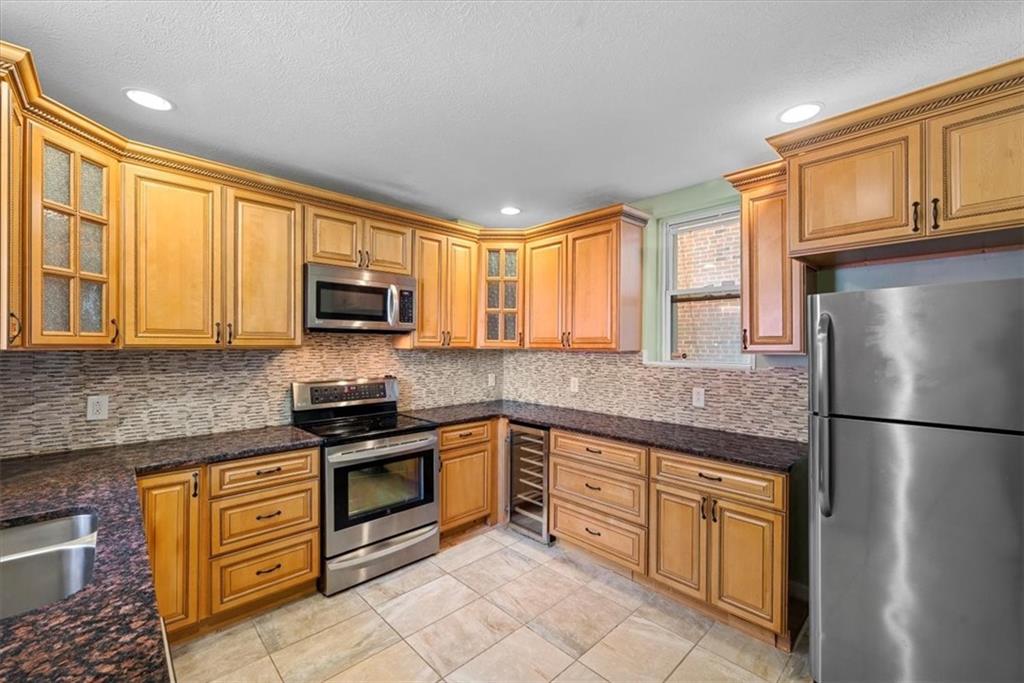 245 37th Street Pittsburgh, PA 15201 - Photo 8 of 29 a kitchen with stainless steel appliances granite countertop a refrigerator stove top oven and sink