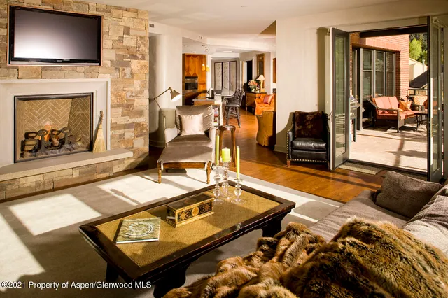 a living room with furniture a flat screen tv and a fireplace
