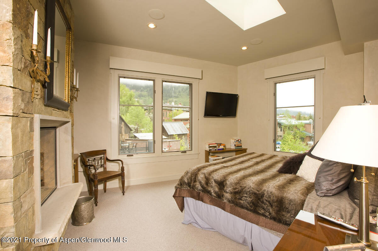 501 Rio Grande Place, Unit 206 Aspen, CO 81611 - Photo 7 of 10 a bed sitting in a bedroom next to a window