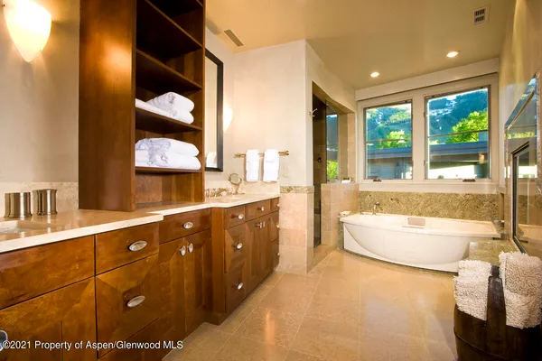 a bathroom with a tub sink and mirror