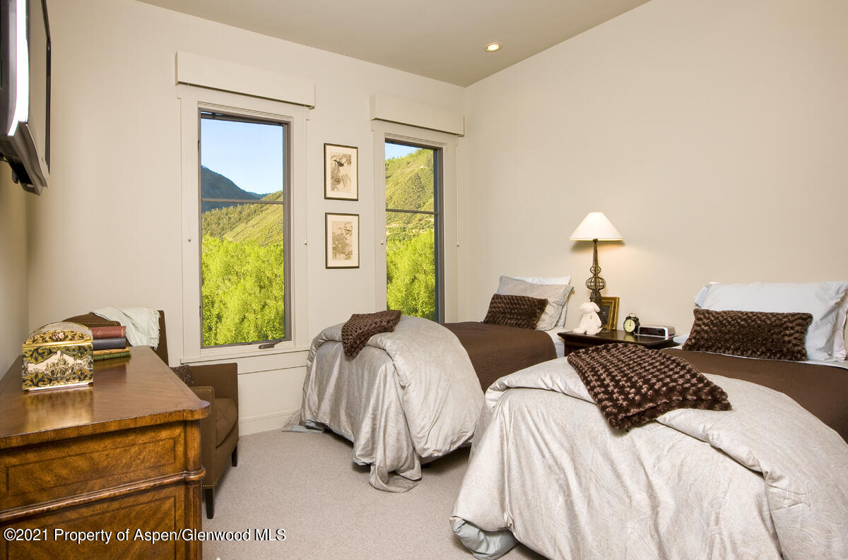 501 Rio Grande Place, Unit 206 Aspen, CO 81611 - Photo 9 of 10 a bedroom with two beds and a window