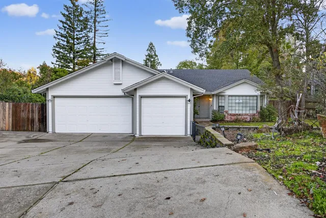a view of a house with a yard and large tree