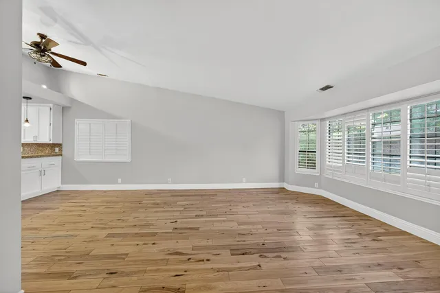 wooden floor in an empty room with a kitchen