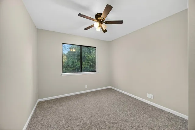 an empty room with closet and windows