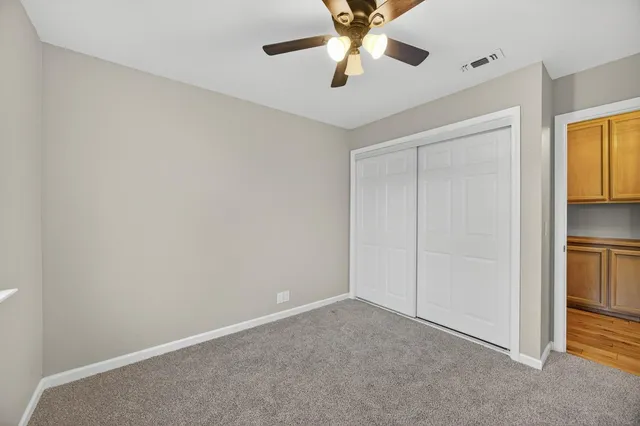 an empty room with a window and a ceiling fan