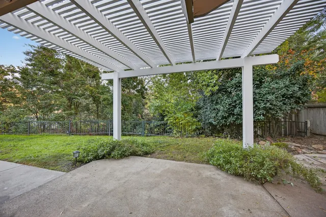 a backyard of a house with trees and wooden fence