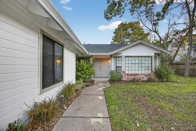 a front view of a house with a garden