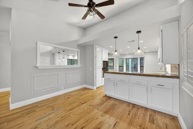 a large kitchen with stainless steel appliances granite countertop a stove a sink and white cabinets