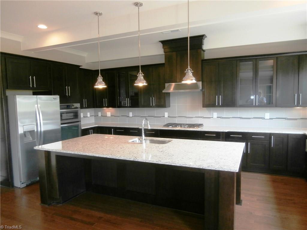 7797 Panda Court Oak Ridge, NC 27310 - Photo 6 of 23 Absolutely the prettiest granite and back splash combination I've seen. Can you believe how many cabinets are here? This home has the cabinet & drawer space of two normal homes. Refrigerator remains. This kitchen exudes class!