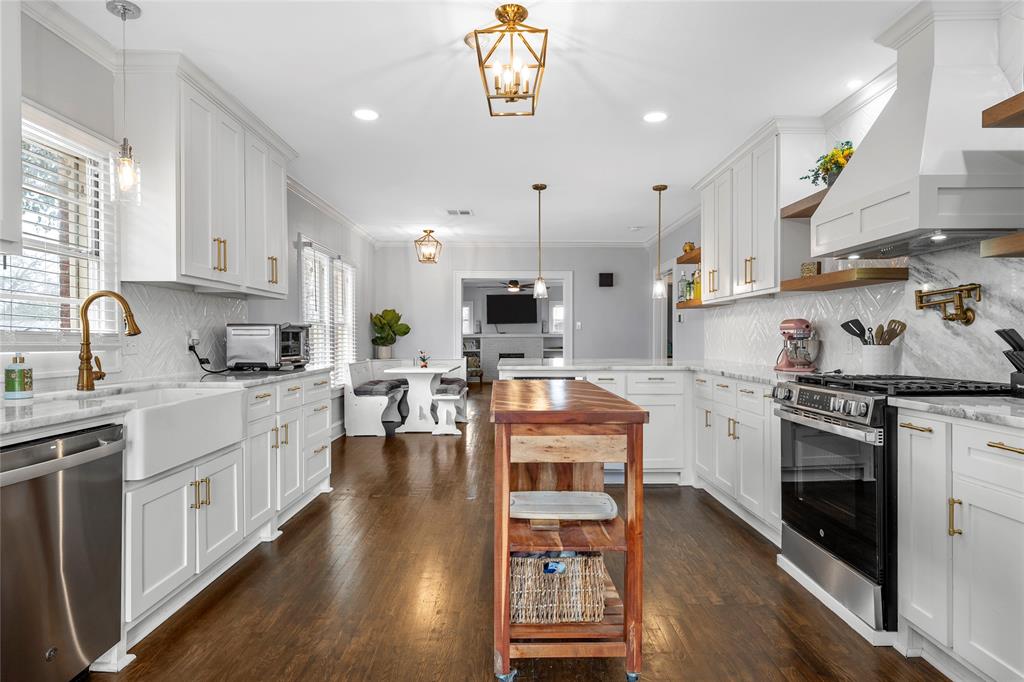 628 North 33rd Street Waco, TX 76710 - Photo 22 of 35 a large kitchen with stainless steel appliances granite countertop a stove oven a sink dishwasher and white cabinets with wooden floor