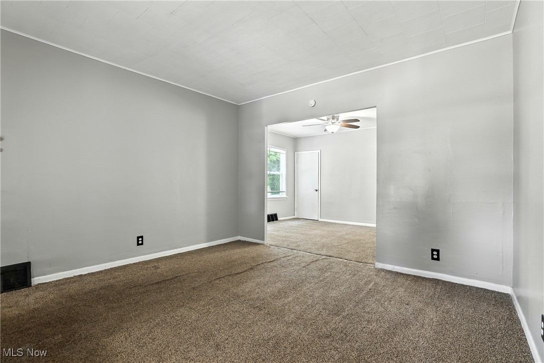 1774 Urbana Road Cleveland, OH 44112 - Photo 7 of 41 Carpeted spare room featuring ceiling fan and baseboards