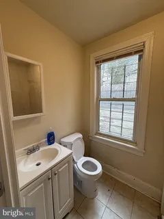 a bathroom with a sink a toilet and a window