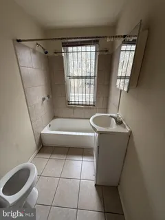 a spacious bathroom with a tub a sink and a toilet