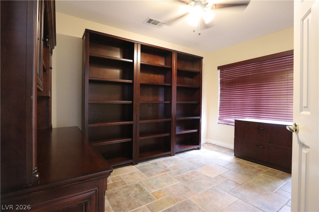 2108 Crestpoint Way Las Vegas, NV 89134 - Photo 17 of 27 Functional home office or library space featuring built-in shelving and ample room for productivity.