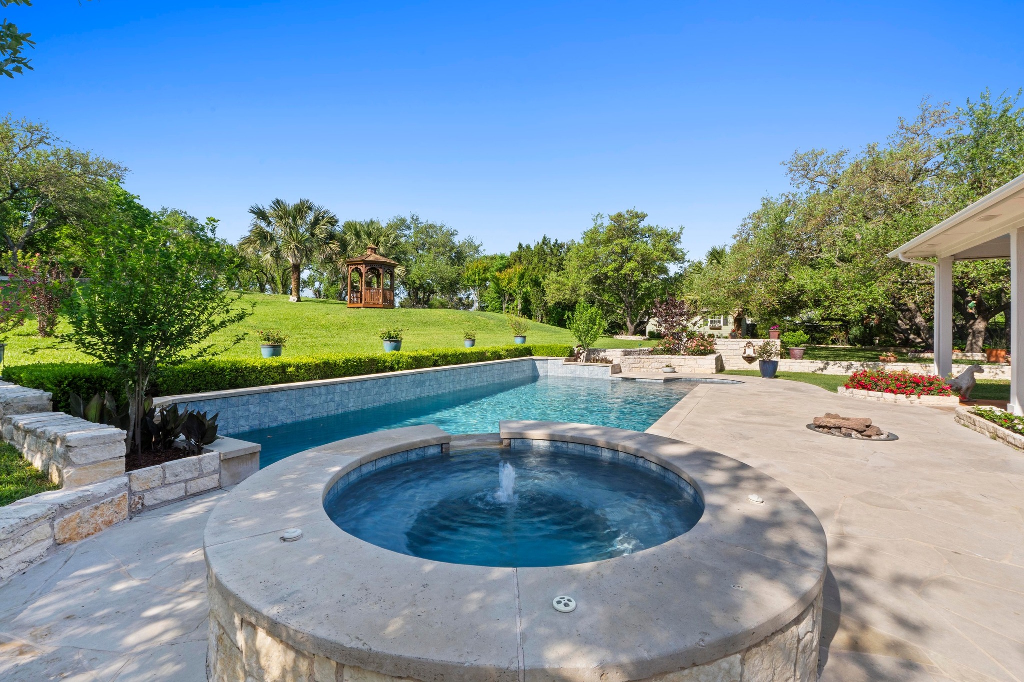 135 Tumbleweed Trail North Austin, TX 78733 - Photo 22 of 39 Combined pool / hot tub featuring a patio, gas firepit, and beautiful landscaping