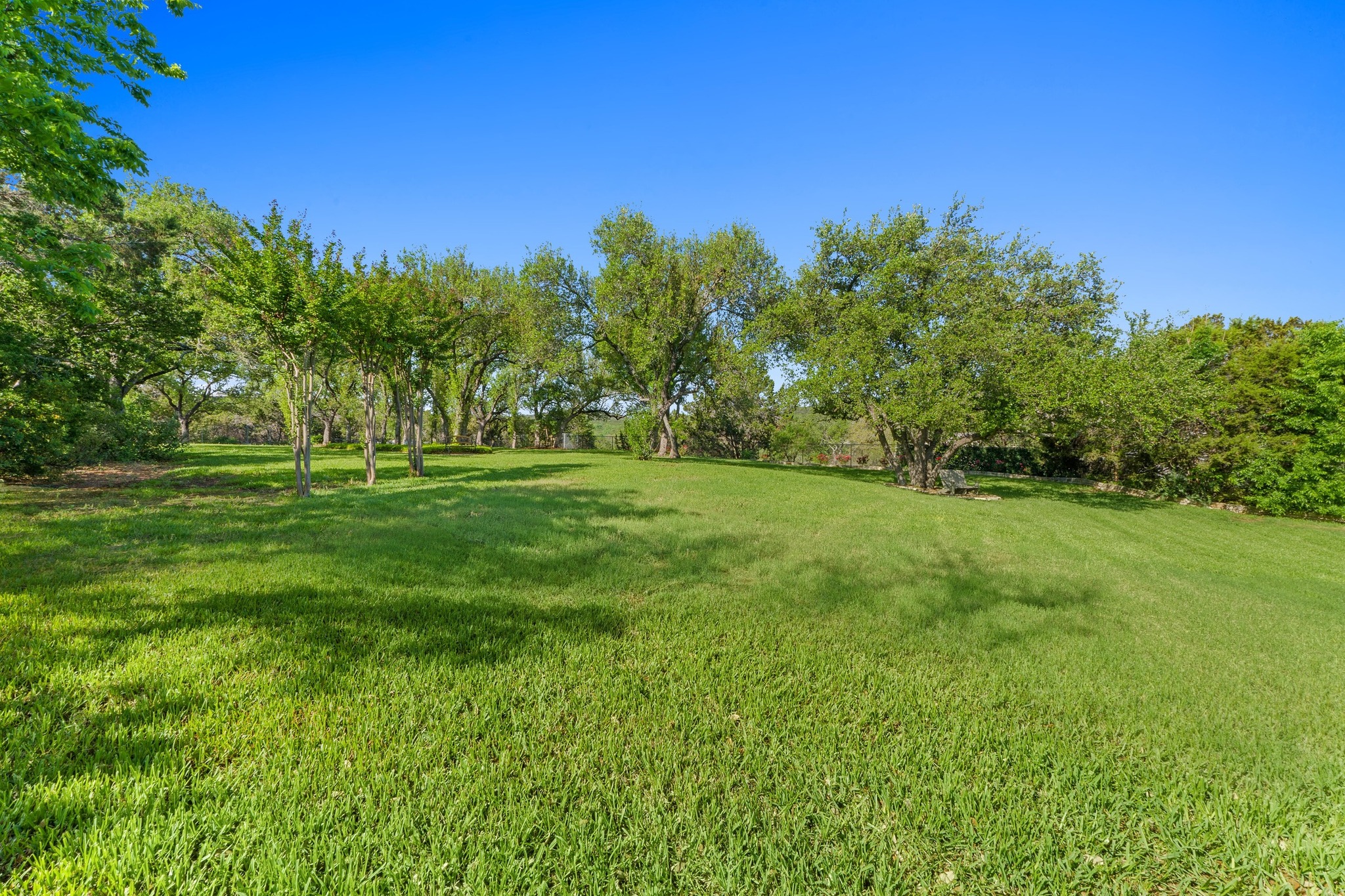 135 Tumbleweed Trail North Austin, TX 78733 - Photo 27 of 39 View of the backyard with a view of woods beyond.