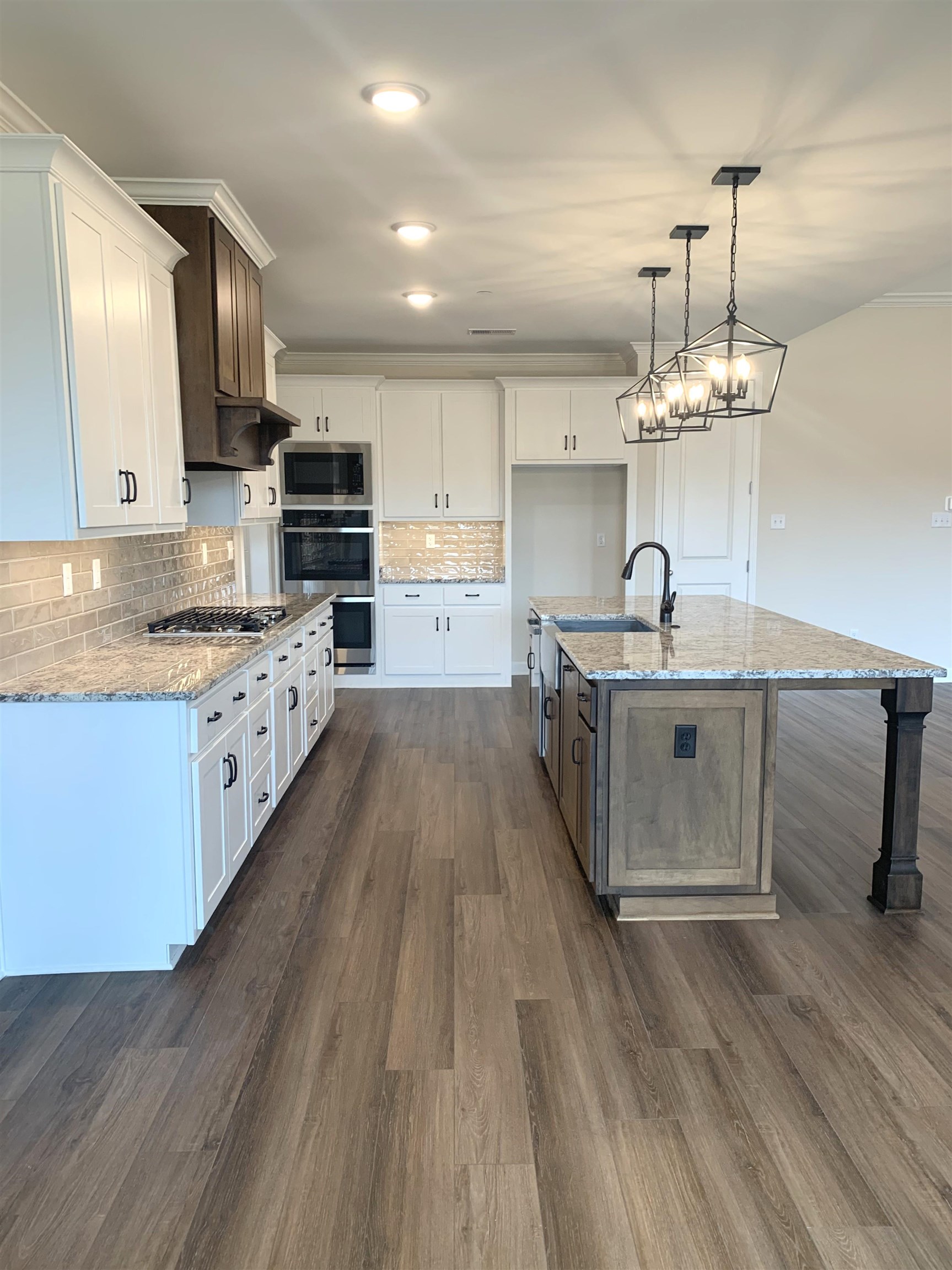 35 Grassy Hill Road Collierville, TN 38017 - Photo 6 of 33 a kitchen with stainless steel appliances a sink dishwasher a stove a microwave oven and a dining table with wooden floor