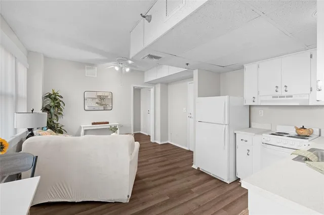 a room with kitchen island a white cabinets and refrigerator