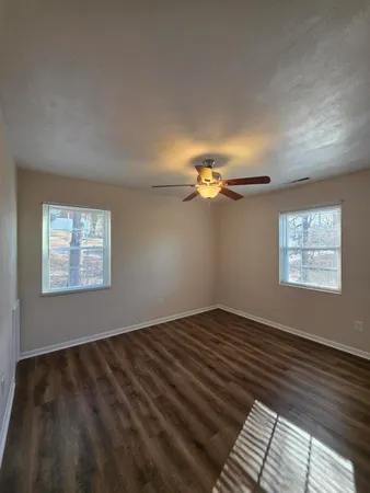 a view of a livingroom with a ceiling fan and hardwood floor