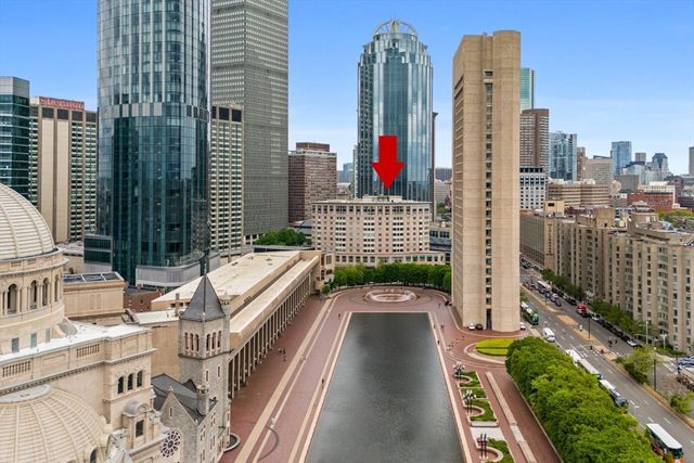 a hallway with painting on the wall and a mirror