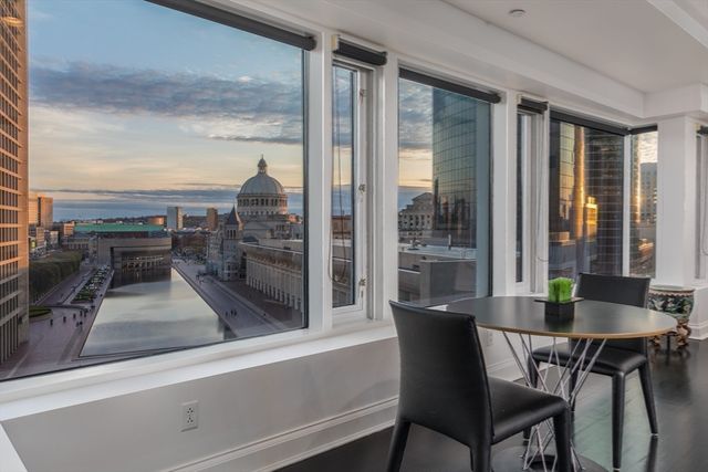 a view of a dining room with furniture wooden floor and painting on the wall